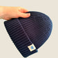 Navy blue ribbed kids’ beanie with cream 1800m Club label. Made in Arosa, Switzerland.