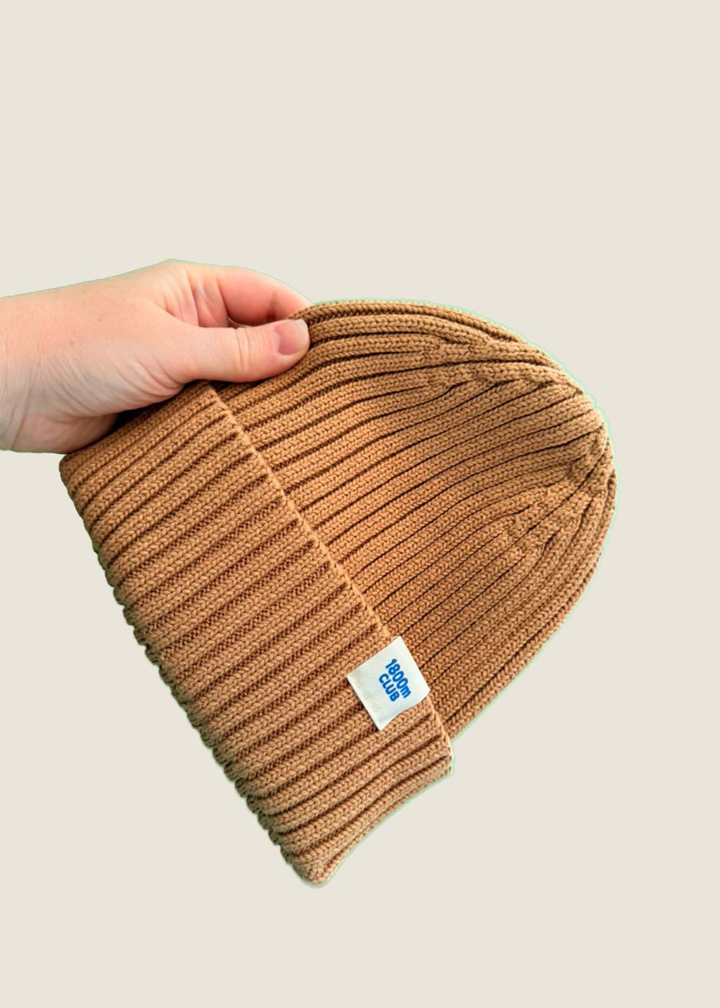Bronze brown ribbed kids’ beanie with cream 1800m Club label. Made in Arosa, Switzerland.