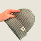 Sage green ribbed kids’ beanie with cream 1800m Club label. Made in Arosa, Switzerland.