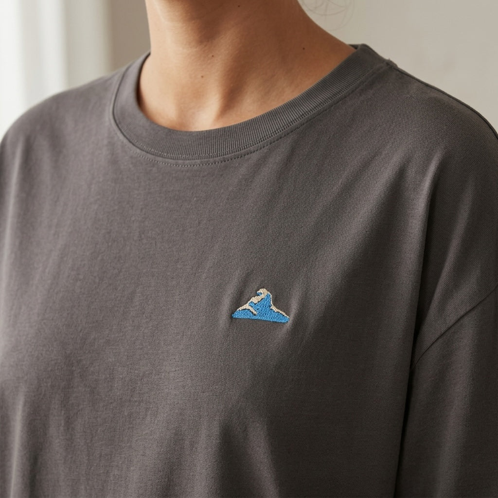 A close up of a woman wearing the 1800m Club Hörnli embroidered Boxy T-shirt designed in Arosa, Switzerland.