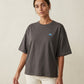 A woman wearing the 1800m Club Hörnli embroidered Boxy T-shirt designed in Arosa, Switzerland.