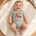 Baby wearing the sage green Ray & Monty Road Trip bodysuit on a cream play mat