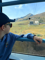 The blue Ray & Monty Road Trip kids' hoodie worn on a cable-car ride in the mountains.